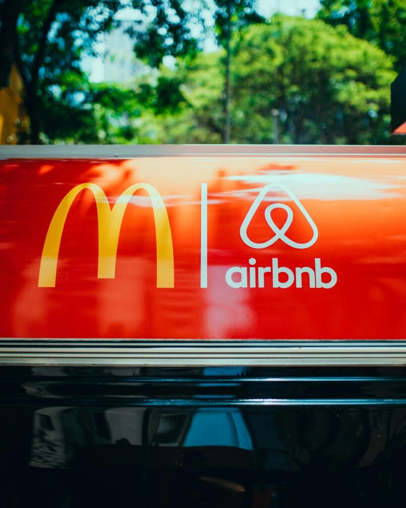 pexels-photo-13870633-13870633 Bright sign showcasing recognizable logos on a vehicle's roof with blurred trees in the background.